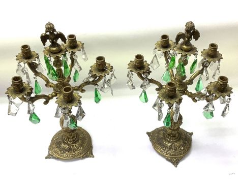 A pair of gilt brass candelabra with clear and green glass lustre drops mounted with a Prussian double headed eagle.