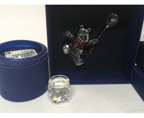 A Winnie the Pooh Disney figure with ruby glass top holding a balloon with the honey pot plaque both with out damage and boxe