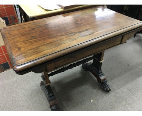 A  Victorian Rosewood card table the rectangle top above square supports United by stretchers .