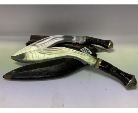 2 Gurkha Kukri knives each with horn and brass handles and lion head motifs.