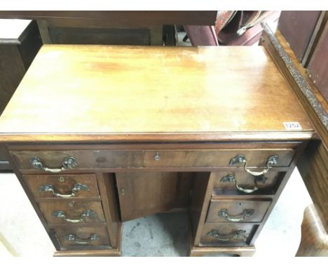 A mahogany kneehole desk fitted with nine drawers central cupboard door On ogee bracket feet . 76 cm by 46 cm