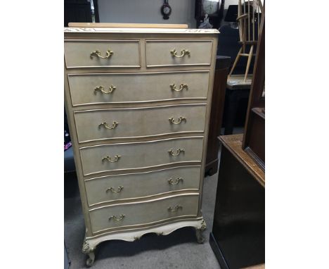 A light walnut chest of drawers fitted with two short and five long drawers On cabriole legs .