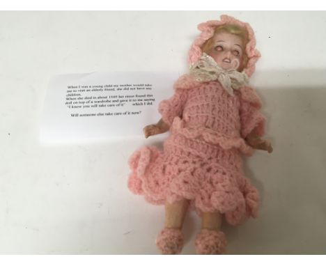 An early 20th century bisque head doll with a vendors note.