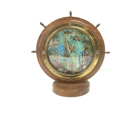 A vintage oak framed table lamp in the form of a ship's wheel with central image of tropical fish, approx total height 25cm.