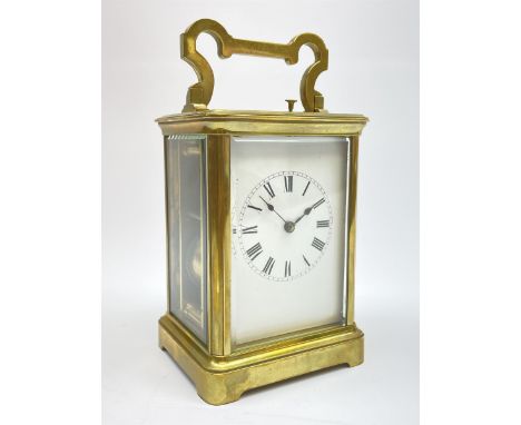 Early to mid 20th century French brass and bevelled glass cased carriage clock, the shaped loop handle over oval glass panel,