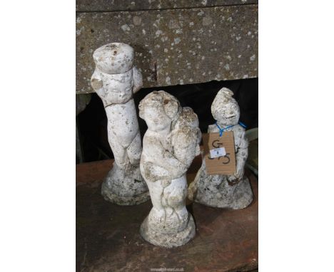 Three concrete garden ornaments.