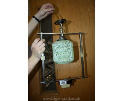 A vintage light fitting with chrome frame and mottled green glass shade.