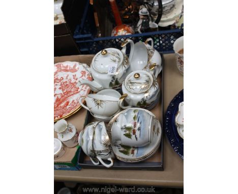 A Japanese Teaset including six cups and saucers, tea pot, lidded sugar pot, milk jug, (one cup with damage) 