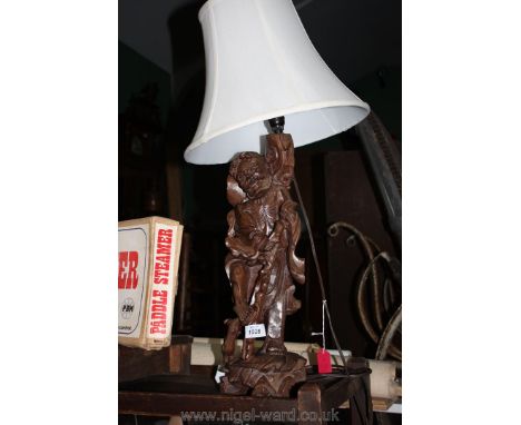 A carved wood table Lamp in the form of an Eastern gent, with shade