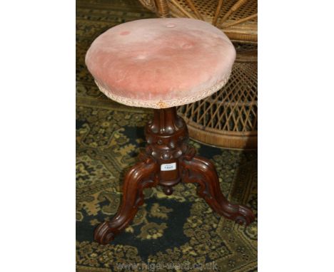 A Victorian Walnut carved tripod based Stool having circular pink upholstered seat top