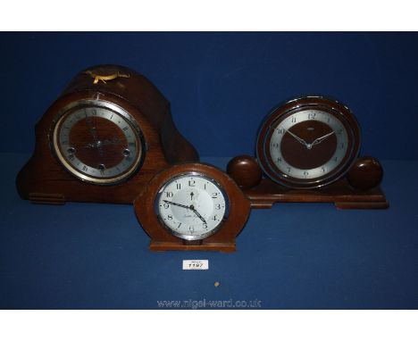 A large wooden mantle Clock and two smaller ones.