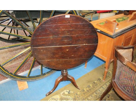 A dark Oak snap-top Table having a turned pillar and three splay feet, 27 3/4'' diameter x 26 1/2'' high