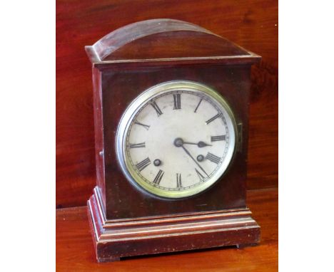 AN EDWARDIAN MANTEL CLOCK WITH A SILVERED CIRCULAR DIAL ENCLOSING A GERMAN EIGHT DAY CHIMING AND STRIKING MOVEMENT, IN A MAHO