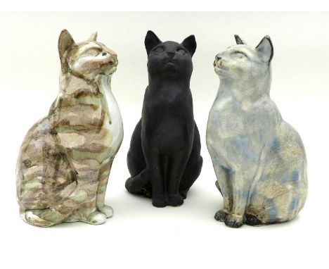 A group of three Northshore Ceramic cats, all the same casting but of differing colours and glaze finishes, one black with ma