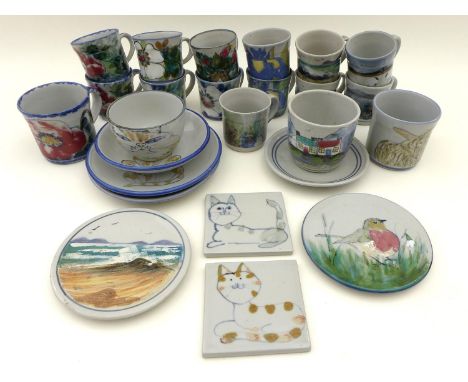 A group of Highland Stoneware pottery, comprising two circular trivets, two small tiles depicting cats, two small plates, two