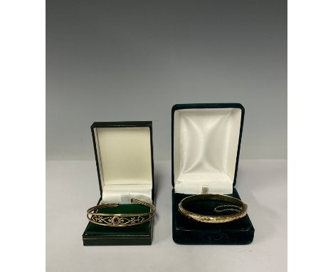 A 9ct gold openwork bangle, set with a single facetted oval amethyst, marked 375, 4.9g, boxed; a 9ct gold hinged bangle, safe