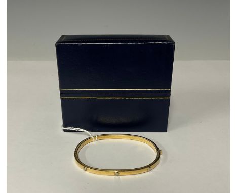 A 9ct gold hinged bangle, cast with six rivets, 6cm interior, marked 375, 6.5g, boxed 