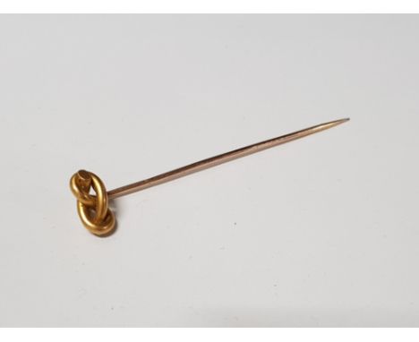 A YELLOW METAL STICK PIN WITH GILT METAL TOP INDISTINCT STAMP TO PIN 1.8G GROSS