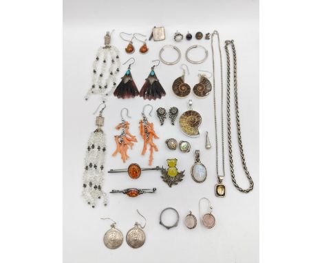 A collection of silver and white metal jewellery, including a ammonite suite of earrings and a pendant set in silver, two amb