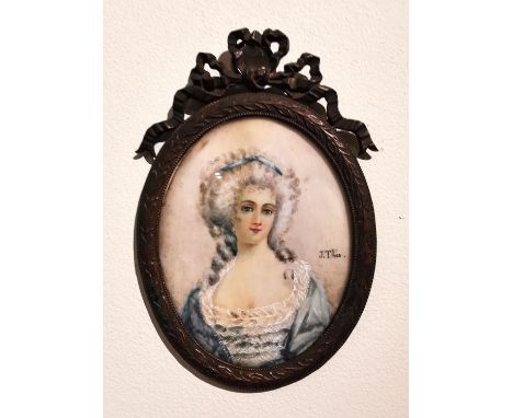 A brass framed and glazed 19th century portrait miniature of a lady in a blue silk dress with pearl drop earrings and bow in 