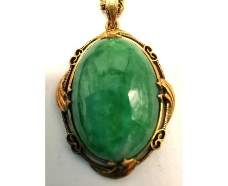 A vintage 14 carat yellow gold and jade pendant with fine curb link chain. The pendant set with a oval Jade cabochon with an 