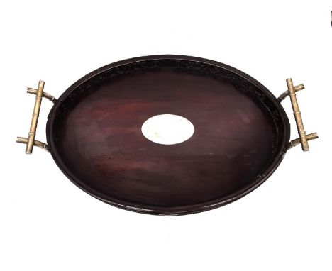An early 20th century Chinese carved and pierced hardwood oval tray with white metal (tests as silver) bamboo form handles an