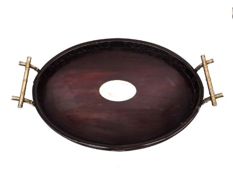 An early 20th century Chinese carved and pierced hardwood oval tray with white metal (tests as silver) bamboo form handles an