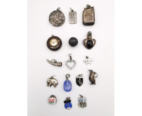 A collection of charms and silver pendants, including an Art Nouveau locket pendant, the front with a lady and flowers, a com