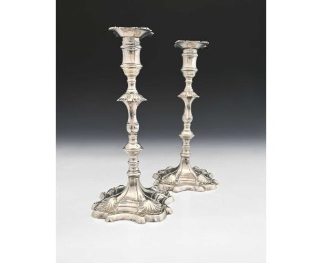 A pair of eighteenth-century, early George III silver cast candlesticks, each with a baluster knop stem, atop a panelled and 