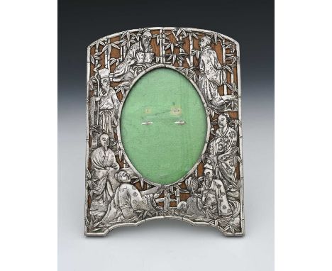 A late nineteenth or twentieth-century white metal photograph frame, decorated in the Eastern style, featuring seated traditi