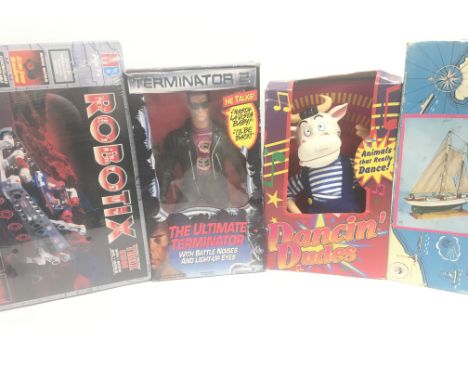 A Box Containing a Robotic Set. A Terminator Figure. A Dancing Dude and a model of a Yacht. All boxed.