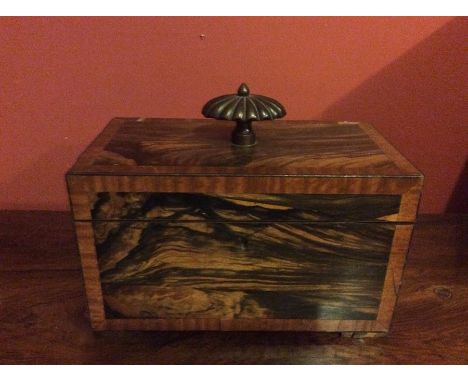 A 19th Century coromandel tea caddy, satinwood cross-banded edges, finial to top, the lid enclosing a fitted interior