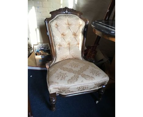 A victorian walnut nursing chair, the top carved cartouche and scrolls, chanelled scrolling frame, buttoned upholstered back 