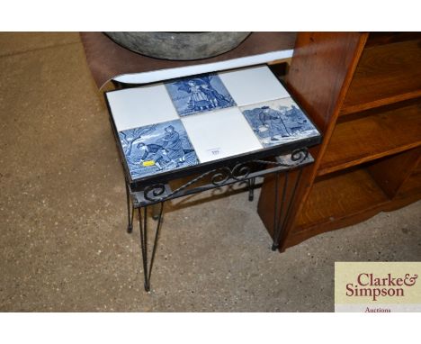 A wrought metal occasional table with decorative tile top