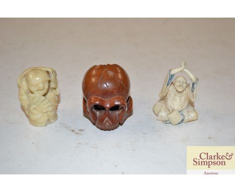 A Japanese ivory netsuke; an okimono and a wooden skull netsuke