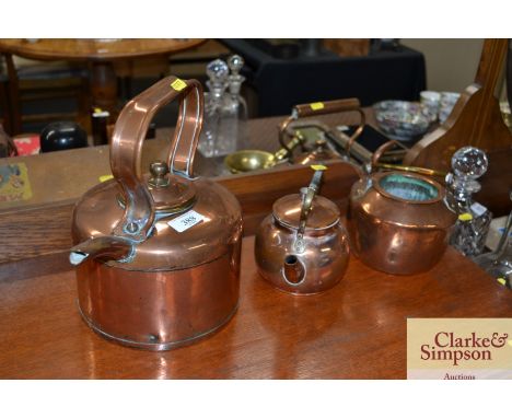 An antique copper kettle; a copper teapot with brass bound handle; and an antique copper glue pot 