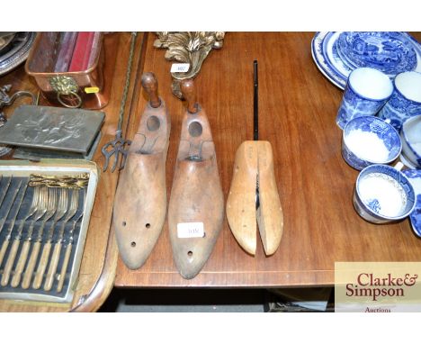 A pair of vintage wooden shoe trees; and a single similar 