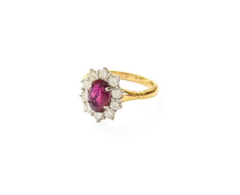 An 18 Carat Gold Red Stone and Diamond Cluster Ring, the oval cut red stone within a border of round brilliant cut diamonds, 