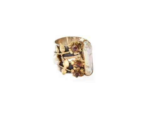 A Split Pearl and Garnet Ring, the white broad shank, overlaid centrally with a floral motif, finger size SUnmarked, in our o