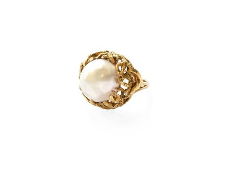 A Mabe Pearl Ring, the mabe pearl within a yellow abstract textured surround, to a forked shoulder plain polished shank, fing