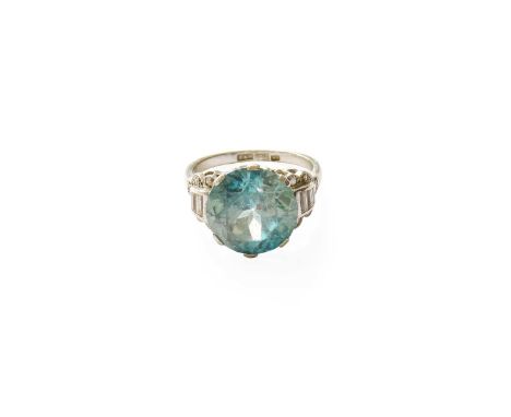 A Blue Zircon and Diamond Ring, the round cut blue zircon in a white claw setting, to baguette cut, round brilliant cut and e