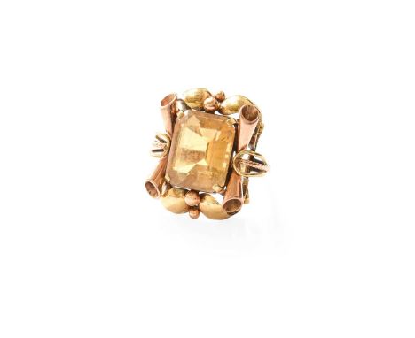 A Citrine Ring, the emerald-cut citrine in a yellow four claw setting, to a scroll and bead work border, on a plain polished 