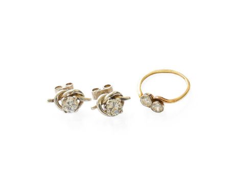 A Diamond Two Stone Twist Ring, the round brilliant cut diamonds, in white rubbed over settings, to a yellow twist shoulder p