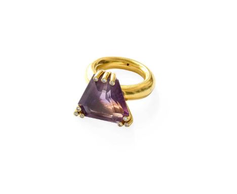 An Amethyst and Diamond Ring, the fancy trilliant cut amethyst in yellow triple claw settings, each inset with a round brilli
