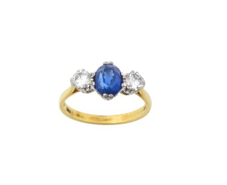 An 18 Carat Gold Blue Stone and Diamond Three Stone Ring, the oval cut blue stone flanked by round brilliant cut diamonds, in