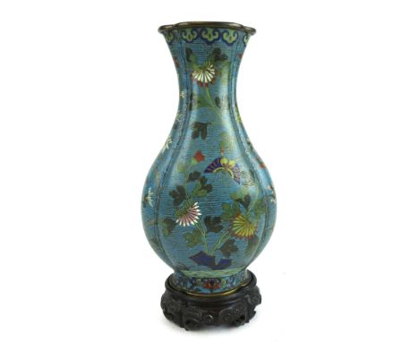 A large oriental Cloisonné vase depicting floral and butterfly scene on a blue ground, on a carved wooden plinth h. 35cm   CO