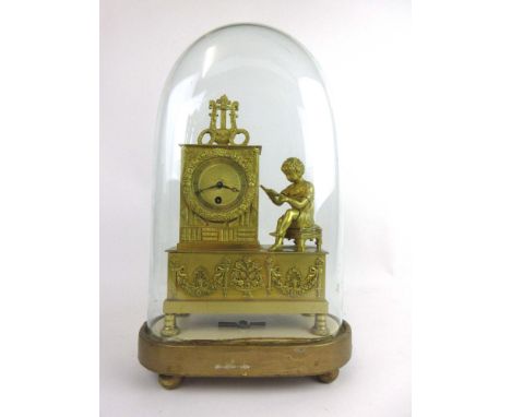 A 19th century gilt brass mantle clock with a reading child figure next to the machined brass face with Roman numerals on a g