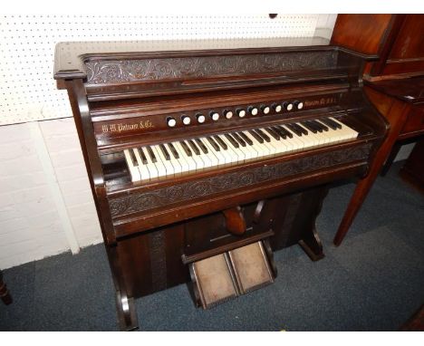 A late 19thC/early 20thC harmonium, stamped W.W. Putnam & Co, Staunton, DA, USA., in a stained walnut case with machine carve