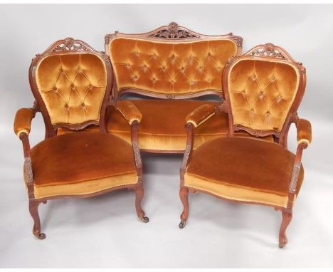 A Victorian walnut three piece suite, comprising a sofa with show frame, button back, padded arms and seat, on cabriole legs,