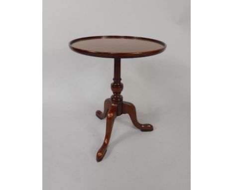 A mahogany occasional table, the circular dished top on a turned column and tripod base, 43cm diameter.